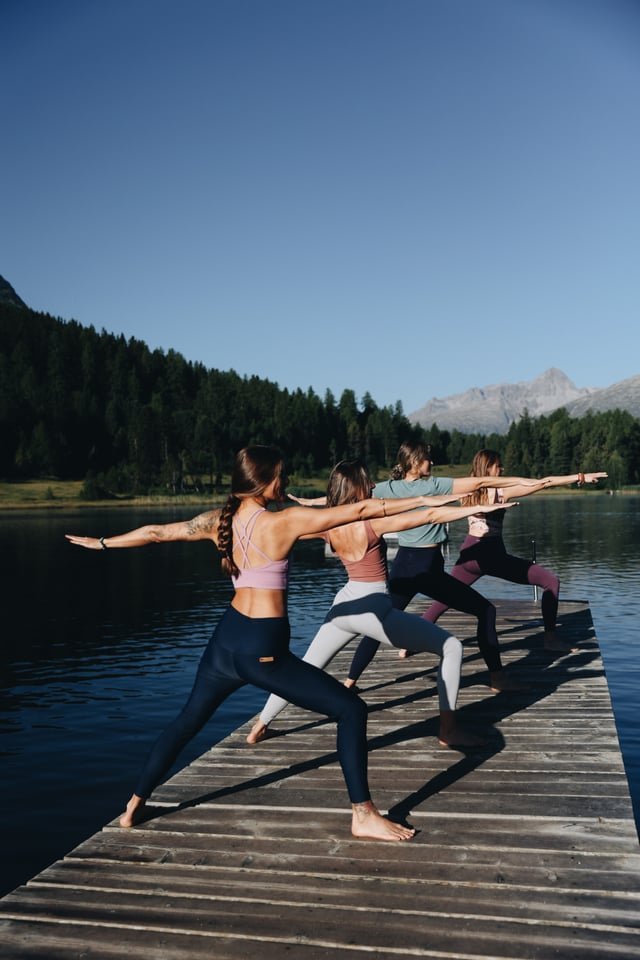 Yoga on a jetty by a mountain lake